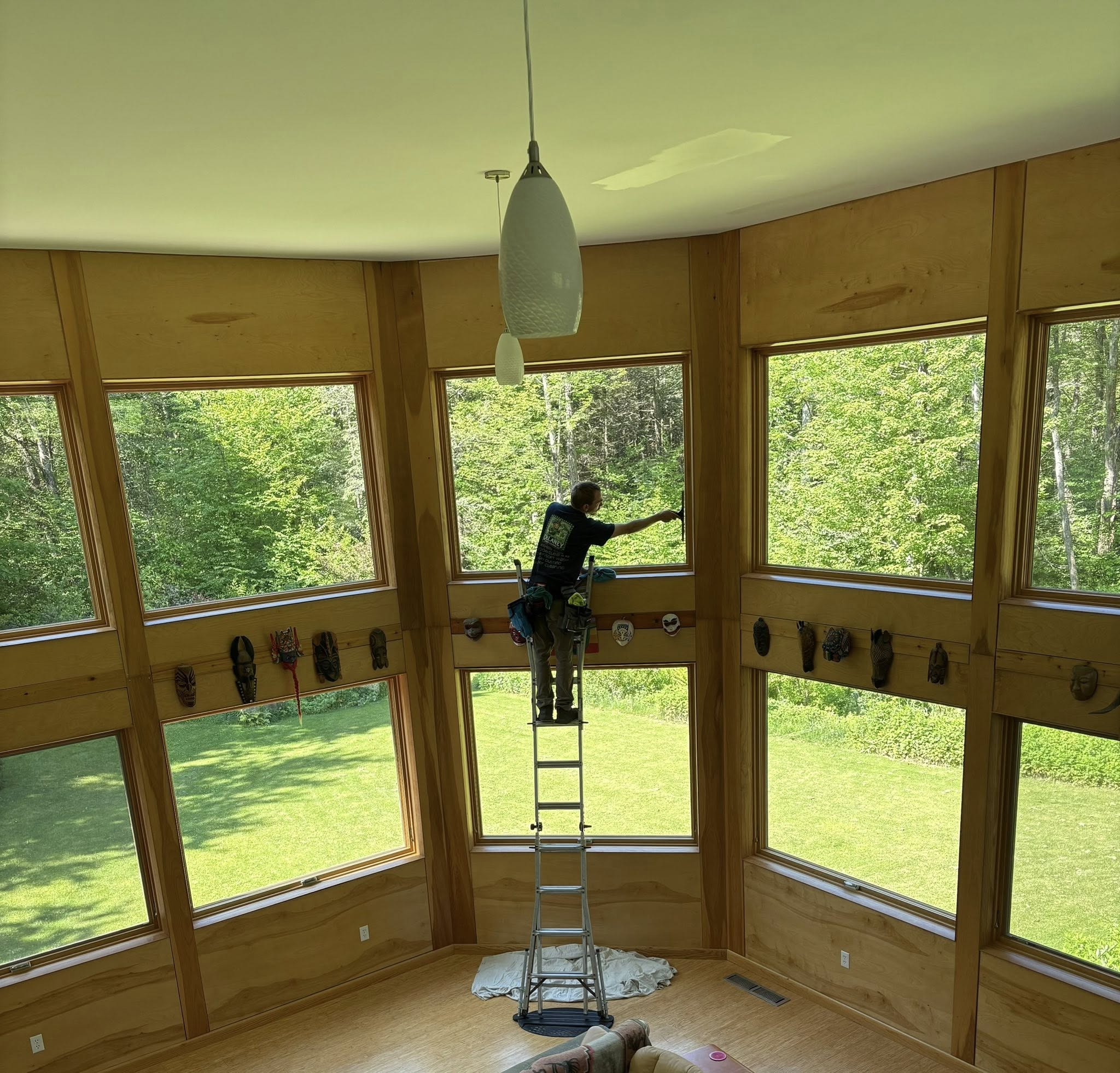 Delaney Window Cleaning professional cleaning tall interior windows from a ladder