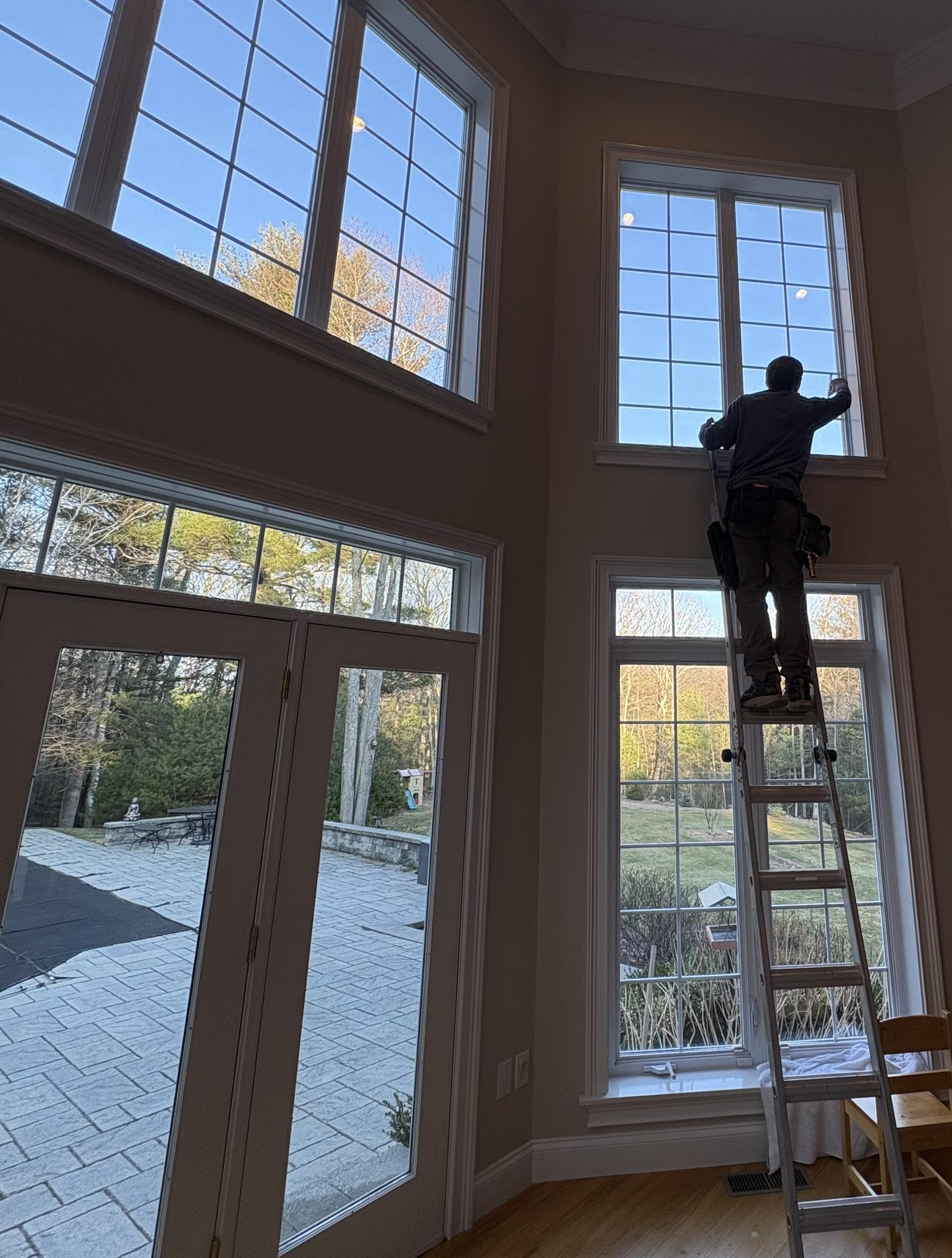 High-access window cleaning in a grand living room with cathedral windows
